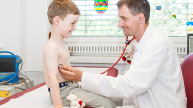 Arzt hört kleinen Patienten mit Stethoskop die Lunge ab