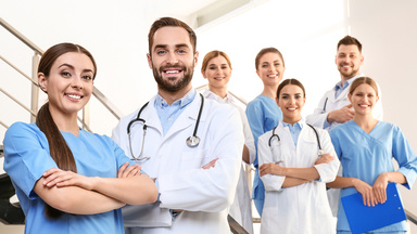 Mehrere lächelnde Ärzte stehen auf einer Treppe