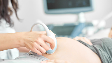 Eine Ärztin führt einen Ultraschall bei einer schwangeren Frau durch